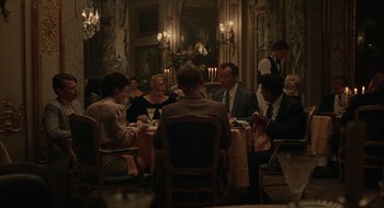 Movie still from “The Nest” (2020), directed by Sean Durkin – A group of people sitting around a table at a restaurant; Wide shot, High angle