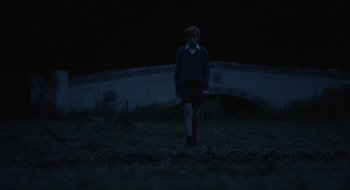 Movie still from “The Nest” (2020), directed by Sean Durkin – A person standing in a field at night; Wide shot, Over the shoulder angle
