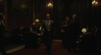 Movie still from “The Nest” (2020), directed by Sean Durkin – A man in a suit and tie walking in a room; Wide shot, Over the shoulder angle