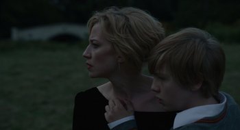 Movie still from “The Nest” (2020), directed by Sean Durkin – A woman standing next to a boy in a park; Close Up shot, Over the shoulder angle