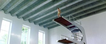 Movie still from “The NeverEnding Story II: The Next Chapter” (1990), directed by George Miller – A man standing on top of a metal platform; Extreme Wide shot, Low angle