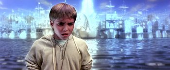 Movie still from “The NeverEnding Story II: The Next Chapter” (1990), directed by George Miller – A young boy in front of an ocean scene; Close Up shot, High angle