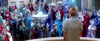 Movie still from “The NeverEnding Story II: The Next Chapter” (1990), directed by George Miller – A group of people dressed in costumes and holding umbrellas; Wide shot, High angle