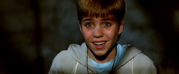 Movie still from “The NeverEnding Story II: The Next Chapter” (1990), directed by George Miller – A young boy with a big smile on his face; Close Up shot, High angle