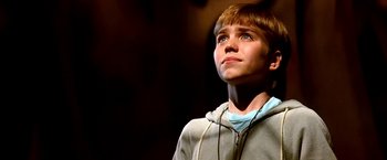Movie still from “The NeverEnding Story II: The Next Chapter” (1990), directed by George Miller – A young boy wearing headphones looking up at the sky; Close Up shot, Low angle