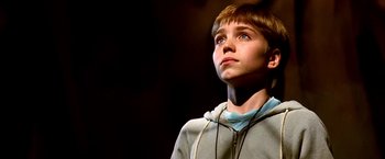Movie still from “The NeverEnding Story II: The Next Chapter” (1990), directed by George Miller – A young boy looking up into the air; Close Up shot, Low angle