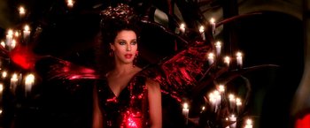 Movie still from “The NeverEnding Story II: The Next Chapter” (1990), directed by George Miller – A woman in a red dress with a red wings; Medium shot, Low angle