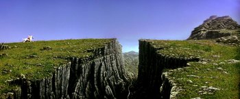 Movie still from “The NeverEnding Story II: The Next Chapter” (1990), directed by George Miller – A view of a mountain from a distance; Extreme Wide shot, Overhead angle
