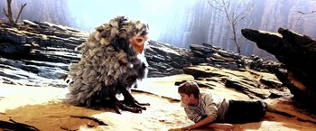 Movie still from “The NeverEnding Story II: The Next Chapter” (1990), directed by George Miller – A boy sitting on the ground next to a bird; Wide shot, High angle