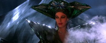 Movie still from “The NeverEnding Story II: The Next Chapter” (1990), directed by George Miller – A woman in a green hat and a green dress; Close Up shot, Low angle