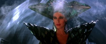 Movie still from “The NeverEnding Story II: The Next Chapter” (1990), directed by George Miller – A woman in a green dress with a green hat on; Close Up shot, Low angle