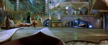 Movie still from “The NeverEnding Story II: The Next Chapter” (1990), directed by George Miller – A person walking in a room with a large staircase; Extreme Wide shot, High angle