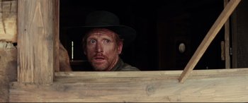 Movie still from “Hostiles” (2017), directed by Scott Cooper – A man in a hat looking over a wooden fence; Close Up shot, Over the shoulder angle