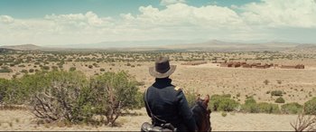 Movie still from “Hostiles” (2017), directed by Scott Cooper – A man riding a horse in the middle of the desert; Extreme Wide shot, Low angle