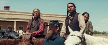 Movie still from “Hostiles” (2017), directed by Scott Cooper – A group of men on horses in a field; Medium shot, Low angle