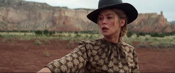 Movie still from “Hostiles” (2017), directed by Scott Cooper – A woman wearing a black hat and a brown and white dress; Medium shot, Low angle