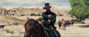 Movie still from “Hostiles” (2017), directed by Scott Cooper – A man on a horse holding a gun in his right hand; Medium shot, Over the shoulder angle