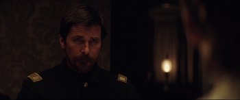 Movie still from “Hostiles” (2017), directed by Scott Cooper – A person wearing a suit and tie; Close Up shot, Over the shoulder angle