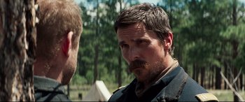 Movie still from “Hostiles” (2017), directed by Scott Cooper – A man with a beard is looking at another man with a beard; Close Up shot, Over the shoulder angle