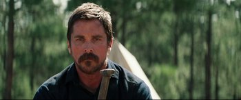 Movie still from “Hostiles” (2017), directed by Scott Cooper – A person with a beard holding a stick; Close Up shot, Over the shoulder angle