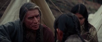 Movie still from “Hostiles” (2017), directed by Scott Cooper – A man with long hair is talking to a young boy; Close Up shot, Over the shoulder angle