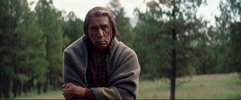 Movie still from “Hostiles” (2017), directed by Scott Cooper – An older native american wearing a blanket and looking sad; Medium shot, Low angle