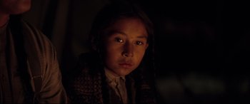 Movie still from “Hostiles” (2017), directed by Scott Cooper – A young native american girl in the dark; Close Up shot, High angle