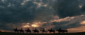 Movie still from “Hostiles” (2017), directed by Scott Cooper – A group of people riding horses on a cloudy day; Extreme Wide shot, Low angle