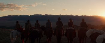 Movie still from “Hostiles” (2017), directed by Scott Cooper – A group of people riding horses on a dirt field; Extreme Wide shot, Low angle