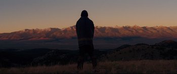 Movie still from “Hostiles” (2017), directed by Scott Cooper – A person standing in a field with mountains in the background; Extreme Wide shot, Low angle