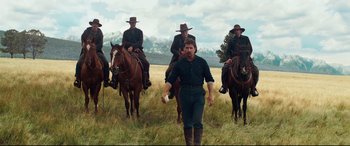 Movie still from “Hostiles” (2017), directed by Scott Cooper – A group of men riding on the backs of horses; Wide shot, Low angle