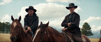 Movie still from “Hostiles” (2017), directed by Scott Cooper – Two men sitting on top of a brown horse; Medium shot, Low angle