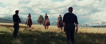 Movie still from “Hostiles” (2017), directed by Scott Cooper – A group of people riding horses in a field; Wide shot, Low angle