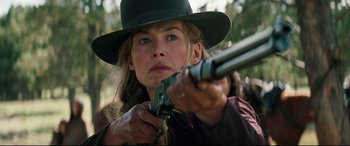 Movie still from “Hostiles” (2017), directed by Scott Cooper – A woman in a green hat is holding a rifle; Close Up shot, Low angle