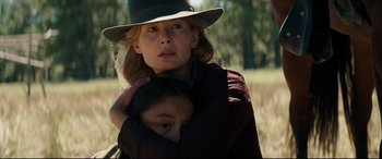 Movie still from “Hostiles” (2017), directed by Scott Cooper – A woman and a child in a field with trees in the background; Close Up shot, Over the shoulder angle