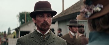 Movie still from “Hostiles” (2017), directed by Scott Cooper – A man with a beard wearing a suit and a hat; Close Up shot, Low angle