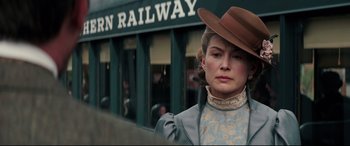 Movie still from “Hostiles” (2017), directed by Scott Cooper – A woman wearing a hat standing in front of a train; Close Up shot, Low angle