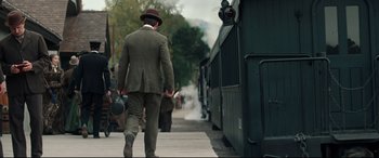 Movie still from “Hostiles” (2017), directed by Scott Cooper – A man walking down a train track next to a train; Wide shot, Over the shoulder angle