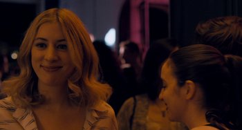 Movie still from “The Night Eats the World” (2018), directed by Dominique Rocher – Two women are talking to each other at a party; Close Up shot, Over the shoulder angle