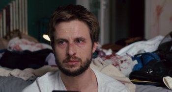 Movie still from “The Night Eats the World” (2018), directed by Dominique Rocher – A person wearing a white shirt; Close Up shot, Over the shoulder angle