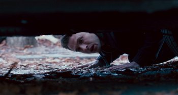 Movie still from “The Night Eats the World” (2018), directed by Dominique Rocher – A young man looking out from under a bridge; Close Up shot, High angle