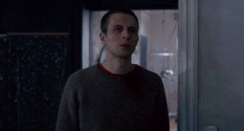 Movie still from “The Night Eats the World” (2018), directed by Dominique Rocher – A man standing in front of a door; Close Up shot, Over the shoulder angle