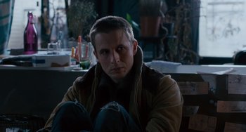 Movie still from “The Night Eats the World” (2018), directed by Dominique Rocher – A man sitting on the ground in a room; Close Up shot, High angle