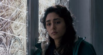 Movie still from “The Night Eats the World” (2018), directed by Dominique Rocher – A young woman is standing in front of a window; Close Up shot, Over the shoulder angle