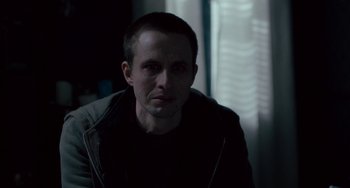 Movie still from “The Night Eats the World” (2018), directed by Dominique Rocher – A person in a dark room; Close Up shot, Over the shoulder angle