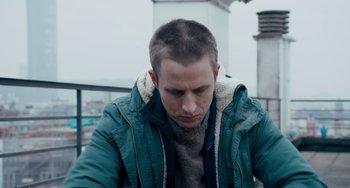 Movie still from “The Night Eats the World” (2018), directed by Dominique Rocher – A person wearing a jacket; Close Up shot, Low angle