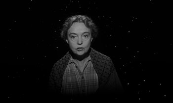 Movie still from “The Night of the Hunter” (1955), directed by Charles Laughton – An old photo of a woman in a black and white photo; Medium shot, High angle
