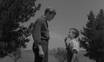 Movie still from “The Night of the Hunter” (1955), directed by Charles Laughton – An old photo of a man and a young boy; Medium shot, Low angle