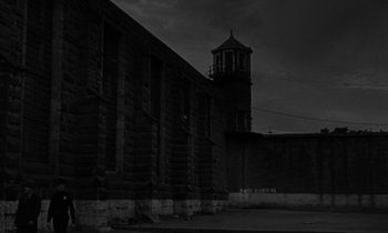 Movie still from “The Night of the Hunter” (1955), directed by Charles Laughton – A building that has a clock on the side of it; Extreme Wide shot, Low angle