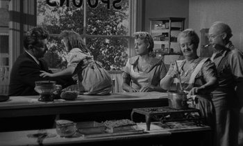 Movie still from “The Night of the Hunter” (1955), directed by Charles Laughton – A group of women sitting at a table in front of a window; Medium shot, High angle